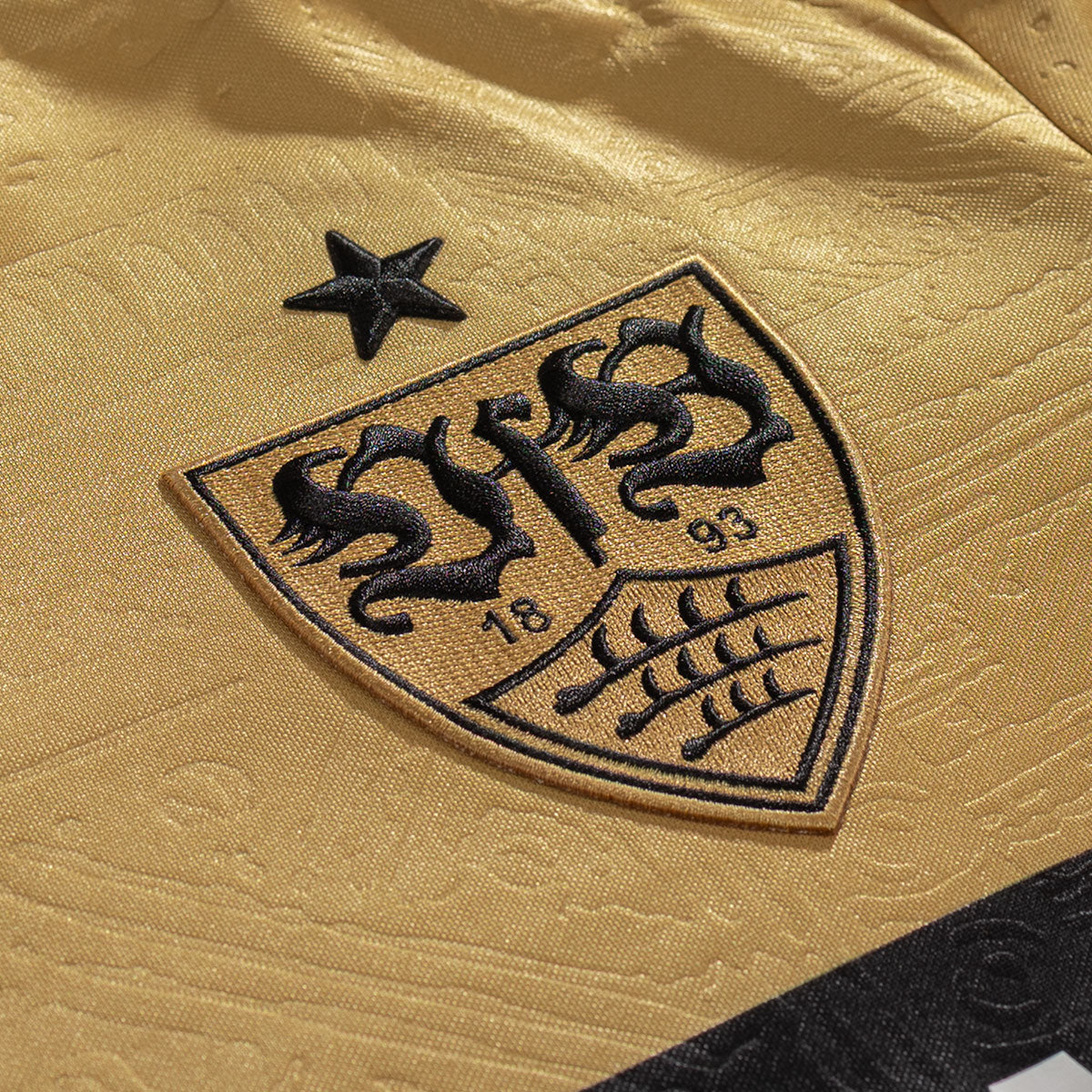 VfB Stuttgart 2026/27 gold Third Jersey crest and fabric detail